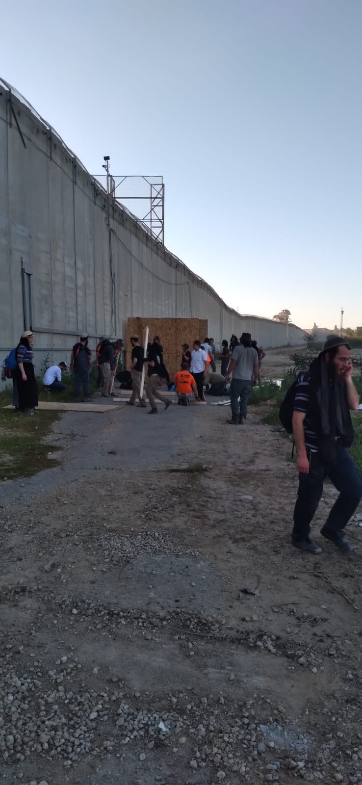 צעירים מעמידים צמוד לגדר המערכת שני מבנים