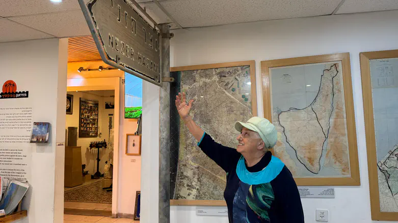 אניטה טוקר ליד השלט של נצר חזני